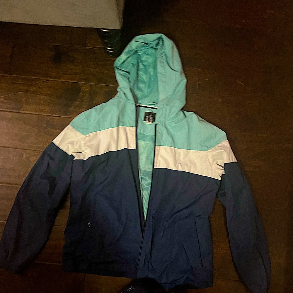 A light sky blue, white, and navy blue rain jacket! Size medium!